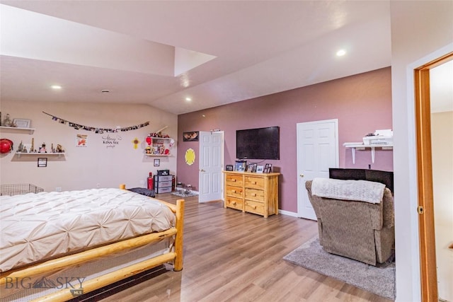 bedroom with hardwood / wood-style floors and lofted ceiling