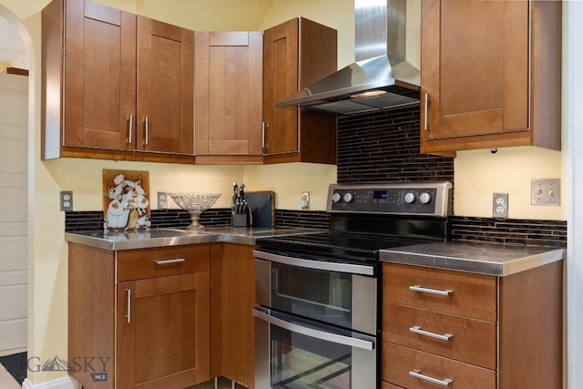 kitchen featuring stainless steel electric stove, stainless steel counters, and wall chimney exhaust hood