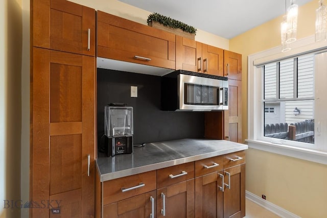 kitchen with plenty of natural light, hanging light fixtures, and stainless steel counters