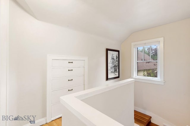 corridor featuring light hardwood / wood-style flooring and vaulted ceiling