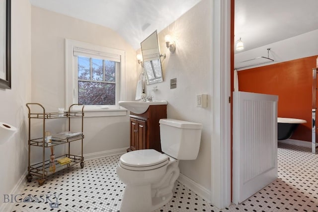 bathroom featuring vanity, toilet, and vaulted ceiling