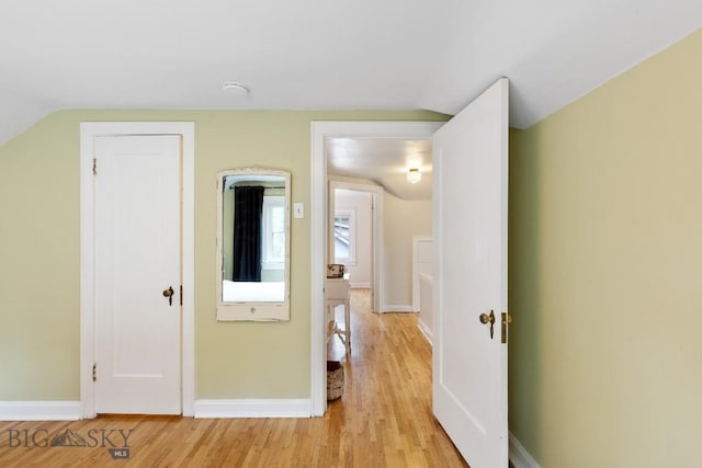 hall featuring light hardwood / wood-style floors and lofted ceiling