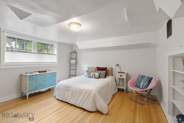 bedroom featuring hardwood / wood-style floors and vaulted ceiling