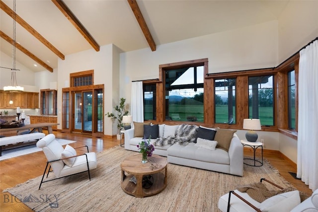 living room featuring high vaulted ceiling, beamed ceiling, light wood-type flooring, and a notable chandelier