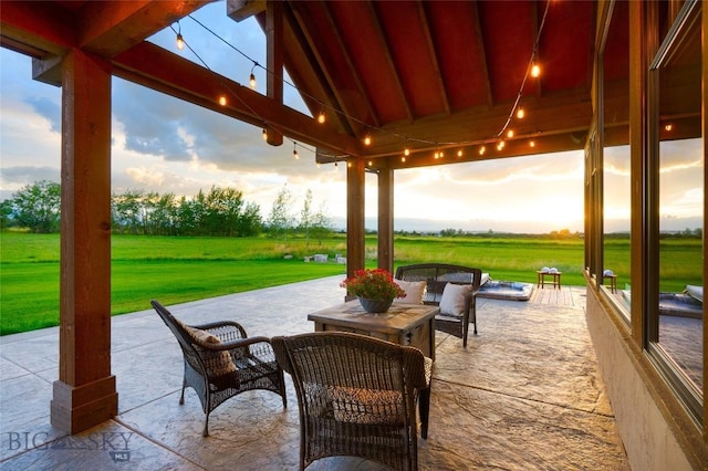 patio terrace at dusk featuring a lawn and an outdoor hangout area