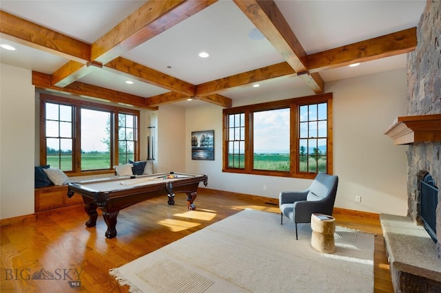 playroom featuring light wood finished floors, beamed ceiling, a fireplace, and baseboards