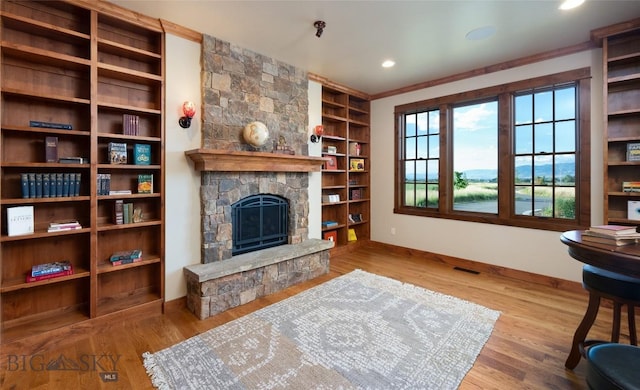 sitting room featuring baseboards, a fireplace, visible vents, and wood finished floors