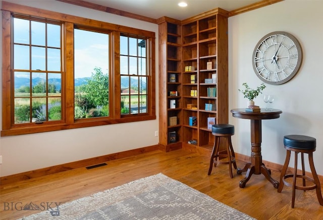 living area featuring baseboards, plenty of natural light, visible vents, and light wood-style floors