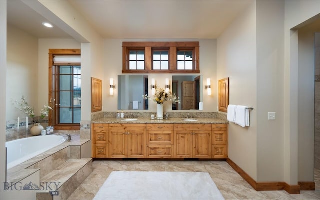 full bathroom featuring a garden tub, plenty of natural light, and a sink