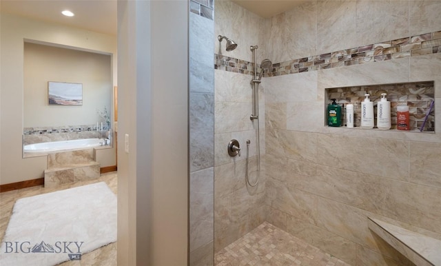 bathroom featuring a garden tub, baseboards, and a tile shower