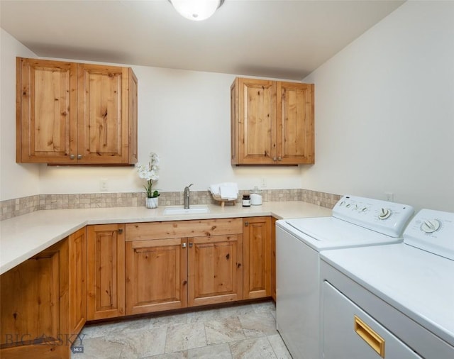 laundry area featuring separate washer and dryer, a sink, and cabinet space