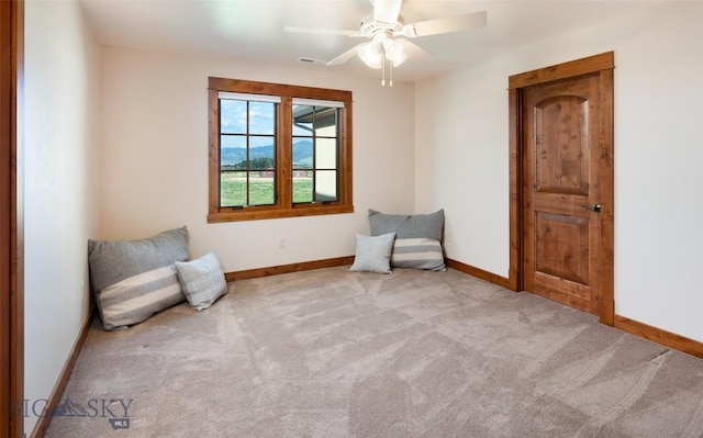 unfurnished room with light carpet, visible vents, baseboards, and a ceiling fan