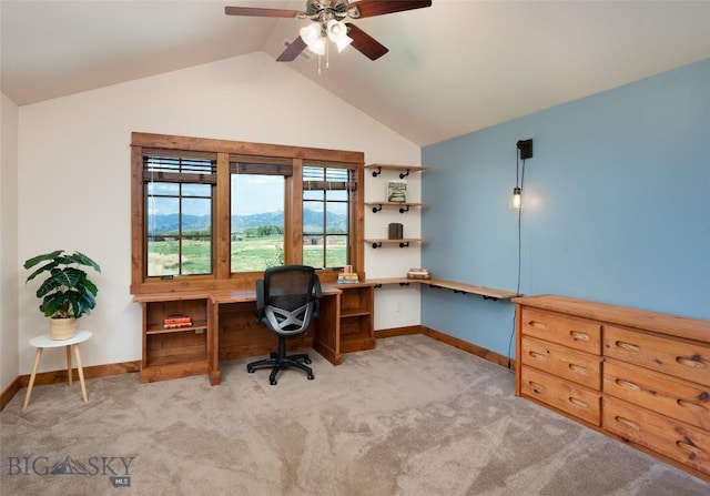 office space with vaulted ceiling, light carpet, a ceiling fan, and baseboards