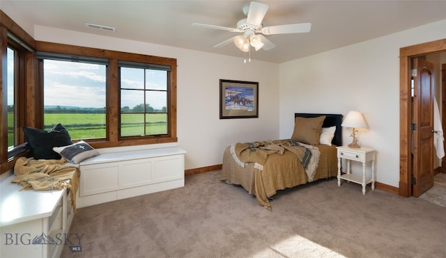 bedroom featuring light carpet, ceiling fan, visible vents, and baseboards