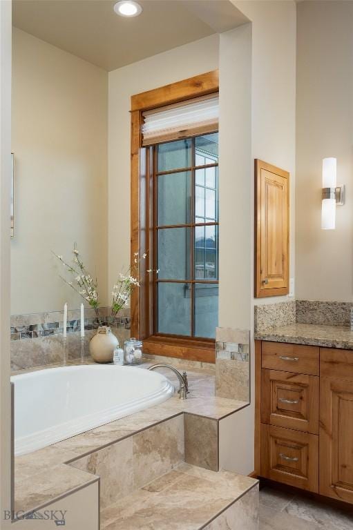 bathroom featuring a garden tub and vanity