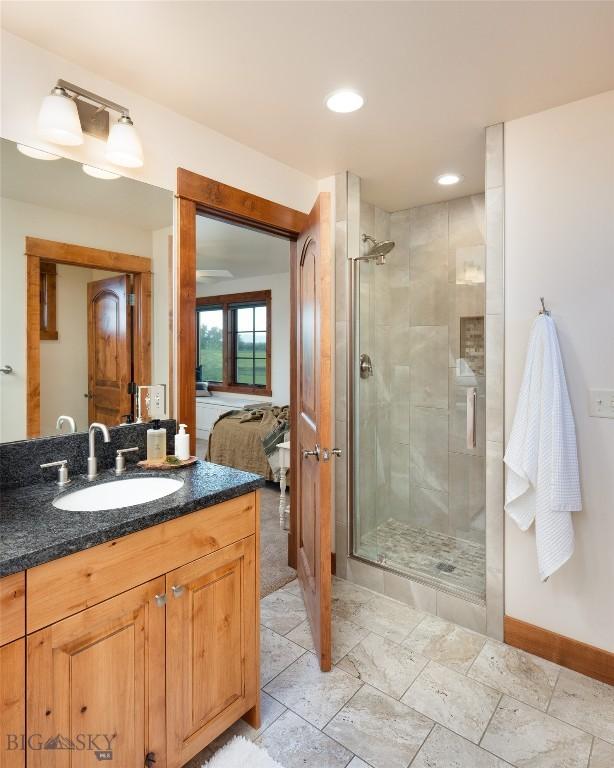 bathroom featuring a stall shower, vanity, baseboards, and recessed lighting