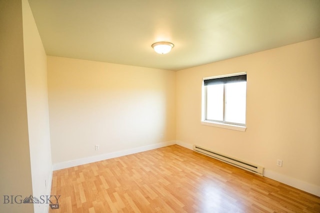 unfurnished room with baseboards, baseboard heating, and light wood-style floors