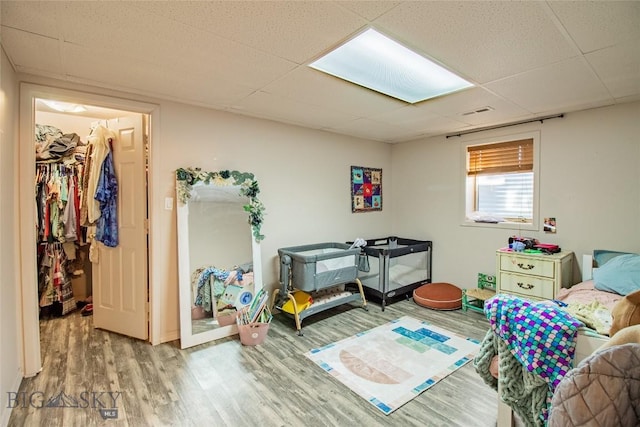 bedroom featuring a drop ceiling and hardwood / wood-style flooring