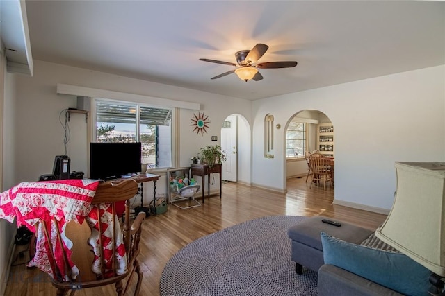 living room with a healthy amount of sunlight, wood-type flooring, and ceiling fan