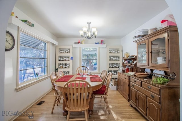 dining room featuring a notable chandelier, plenty of natural light, and light hardwood / wood-style floors