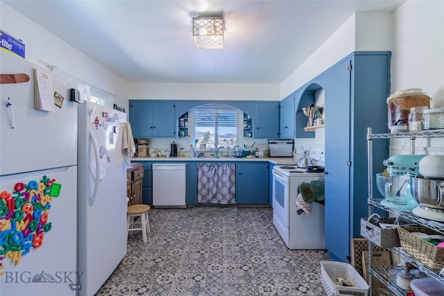 kitchen featuring blue cabinetry, sink, white appliances, and decorative backsplash