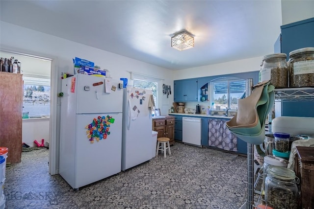 kitchen featuring white appliances and blue cabinets