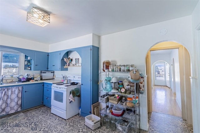 kitchen with sink, white electric range, and blue cabinets