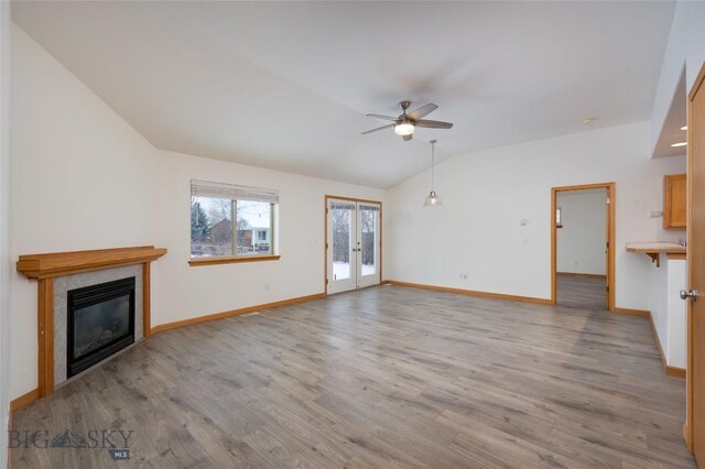 unfurnished living room with french doors, light hardwood / wood-style floors, ceiling fan, and lofted ceiling