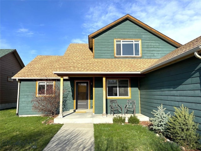 1121 Buckrake Ave, Bozeman, MT 59718 - view of front facade with a porch, a shingled roof, and a front lawn