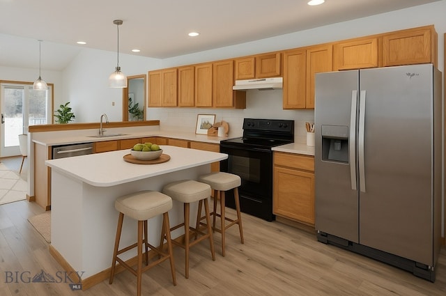 1121 Buckrake Ave, Bozeman, MT 59718 - kitchen with stainless steel appliances, under cabinet range hood, a sink, a peninsula, and light wood-type flooring