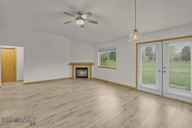 1121 Buckrake Ave, Bozeman, MT 59718 - unfurnished living room featuring lofted ceiling, light wood-style flooring, a ceiling fan, a glass covered fireplace, and baseboards