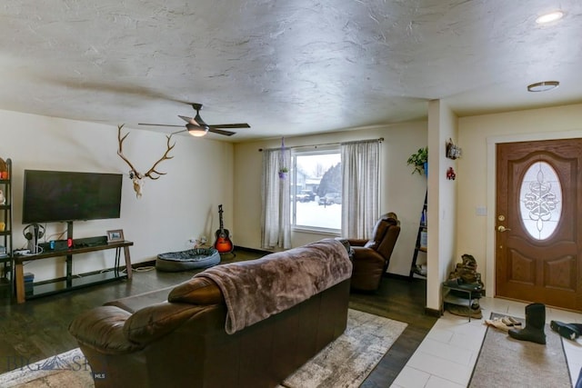 living room with dark hardwood / wood-style flooring, a textured ceiling, and ceiling fan