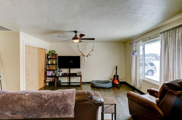 living room featuring wood-type flooring and ceiling fan