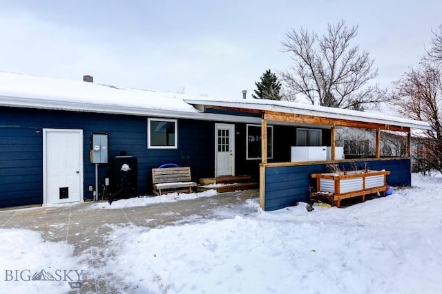 view of snow covered rear of property