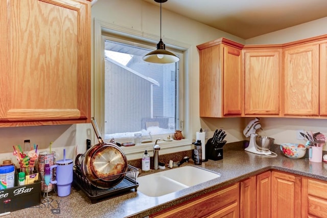 kitchen featuring decorative light fixtures, sink, and light brown cabinetry