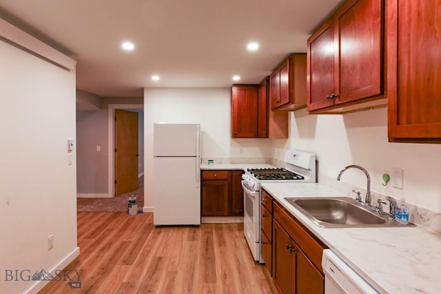 kitchen with white appliances, light hardwood / wood-style flooring, and sink