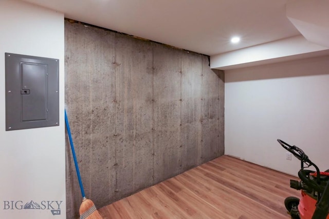 basement with wood-type flooring and electric panel