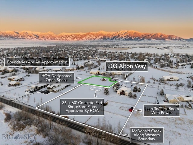 snowy aerial view featuring a mountain view