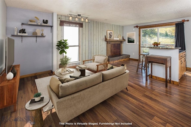 living room with dark hardwood / wood-style flooring, plenty of natural light, and a textured ceiling