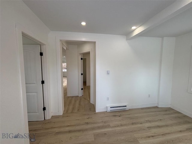 empty room with light wood-type flooring and a baseboard radiator