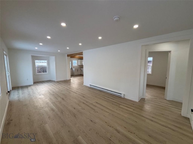 unfurnished living room with a baseboard radiator and light hardwood / wood-style flooring