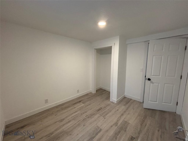 unfurnished bedroom with light hardwood / wood-style flooring and a closet