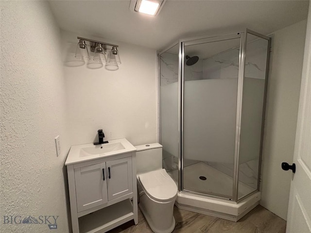 bathroom featuring hardwood / wood-style flooring, vanity, toilet, and a shower with shower door