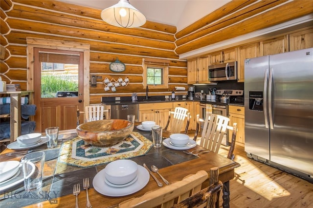 dining area with light hardwood / wood-style floors, log walls, vaulted ceiling, and sink