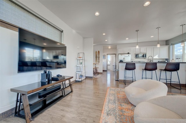 living room with sink and light hardwood / wood-style flooring