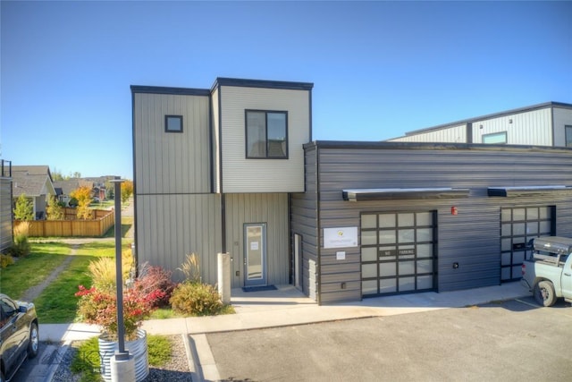 view of front of house featuring fence and a garage