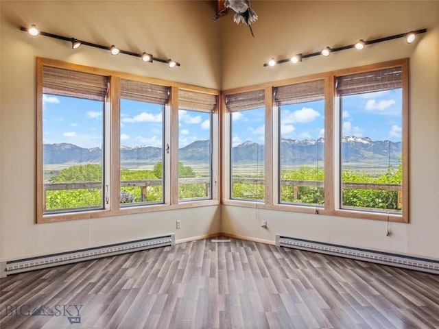 unfurnished sunroom featuring baseboard heating and a mountain view