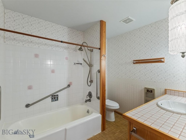 full bathroom with vanity, tiled shower / bath combo, and toilet