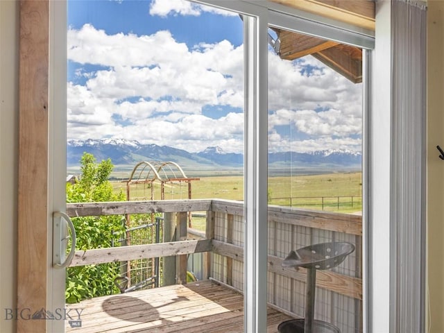 doorway with a mountain view, a rural view, and hardwood / wood-style flooring