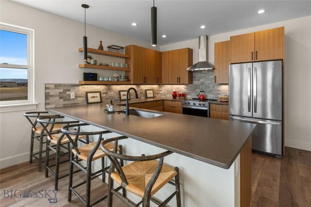 420 Sage Ave Unit B, Ennis, MT 59729 - kitchen featuring dark countertops, a sink, appliances with stainless steel finishes, and wall chimney range hood